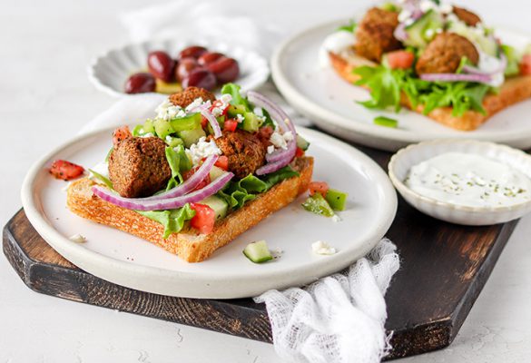 Open falafel sandwiches on chopping board