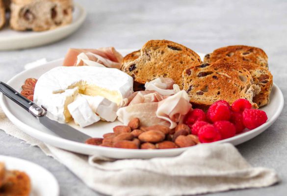 Charcuterie with Hot Cross Bun Crostini on plate with brie, grapes , salami, prosciutto